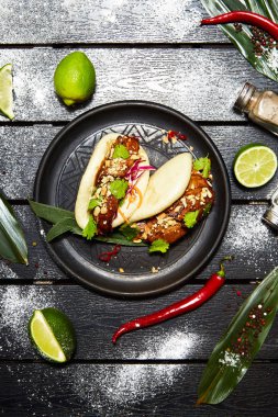 Siyah bir tabakta Asya yemeği. Et ve sebze ile Bao