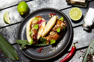 Siyah bir tabakta Asya yemeği. Et ve sebze ile Bao