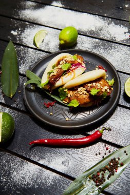 Siyah bir tabakta Asya yemeği. Et ve sebze ile Bao