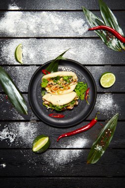 Siyah bir tabakta Asya yemeği. Et ve sebze ile Bao