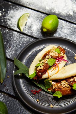 Siyah bir tabakta Asya yemeği. Et ve sebze ile Bao