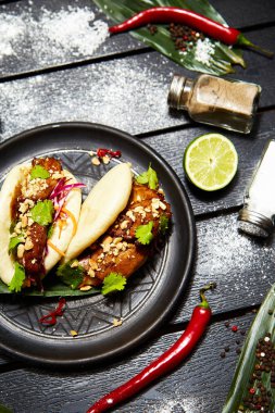 Siyah bir tabakta Asya yemeği. Et ve sebze ile Bao