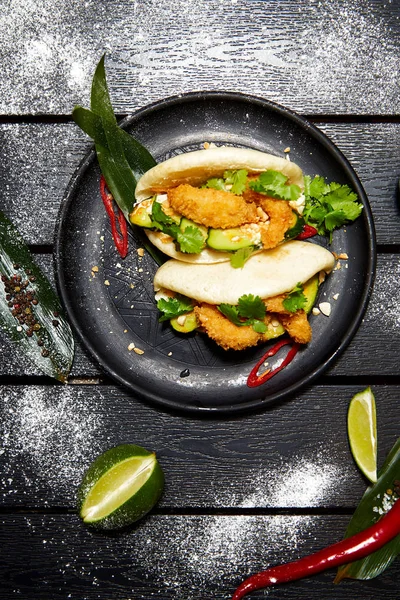 Siyah bir tabakta Asya yemeği. Et ve sebze ile Bao