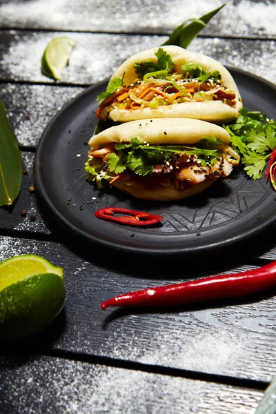 Siyah bir tabakta Asya yemeği. Et ve sebze ile Bao