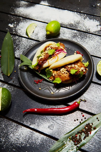 Siyah bir tabakta Asya yemeği. Et ve sebze ile Bao