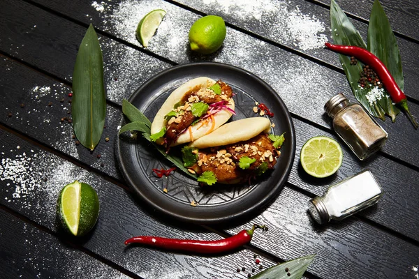 Siyah bir tabakta Asya yemeği. Et ve sebze ile Bao