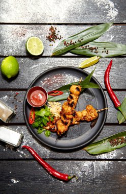 Siyah bir tabakta Asya yemeği. Tavuk Satay