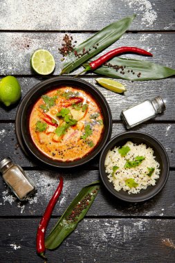 Siyah bir tabakta Asya yemeği. Pirinç ile Tom yum