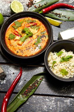 Siyah bir tabakta Asya yemeği. Pirinç ile Tom yum