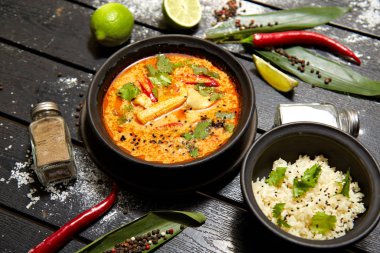 Siyah bir tabakta Asya yemeği. Pirinç ile Tom yum