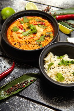Siyah bir tabakta Asya yemeği. Pirinç ile Tom yum