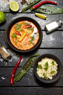 Siyah bir tabakta Asya yemeği. Pirinç ile Tom yum