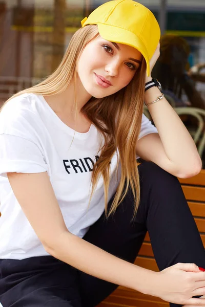 Hermosa chica rubia en una gorra amarilla y camiseta — Foto de Stock