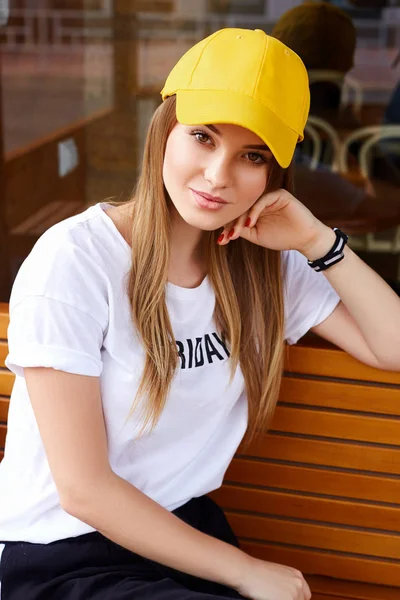 Hermosa chica rubia en una gorra amarilla y camiseta — Foto de Stock