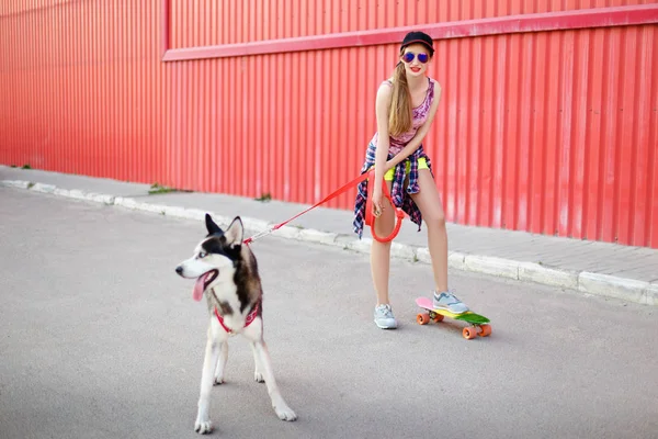 Κορίτσι σε ένα σκέιτμπορντ με ένα σκυλί — Φωτογραφία Αρχείου