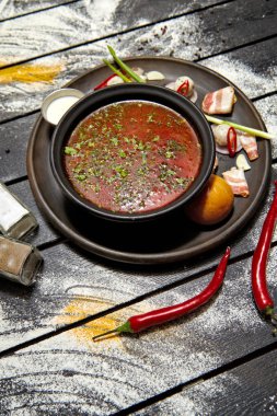 Borsch ekşi krema, soğan ve koyu bir arka plan üzerinde bir topuz ile