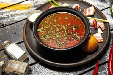 Borsch ekşi krema, soğan ve koyu bir arka plan üzerinde bir topuz ile