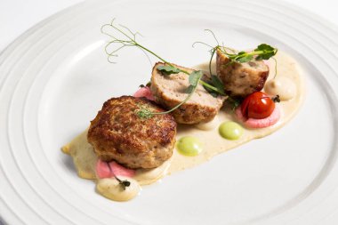 Beyaz bir tabakta soslu köfte