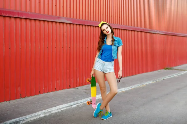 Ragazza in piedi con uno skateboard all'aperto — Foto Stock