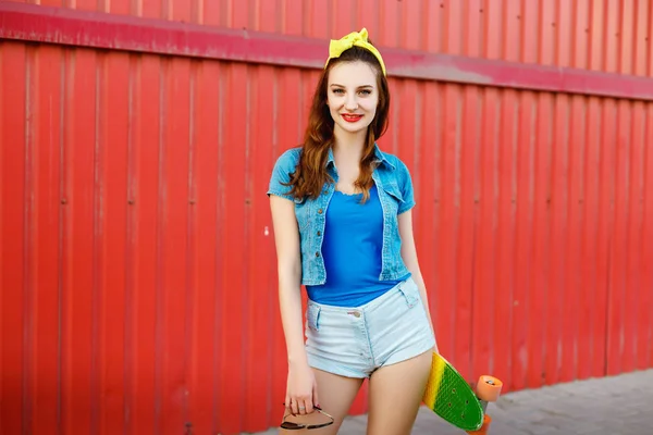 Chica de pie con un monopatín al aire libre — Foto de Stock