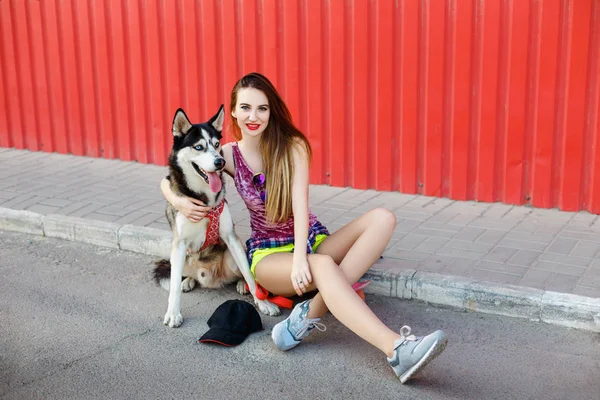 Menina na rua com um cão husky — Fotografia de Stock