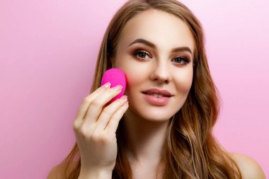 Pembe arka planda makyajlı bir kız.