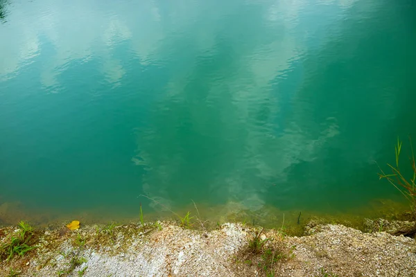 green blue water was born by Cabonate in sandstone and sunlight reflection. In lake of digging for sale dirt surface