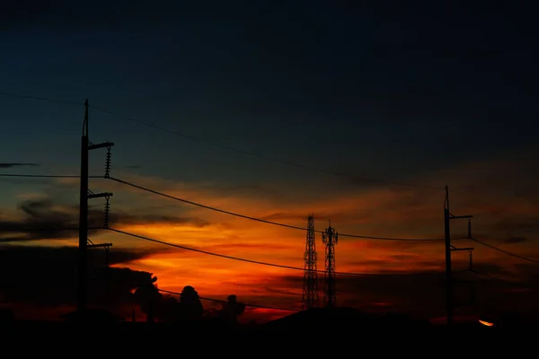 silhouette of power electric line pillar and colorful sunset background