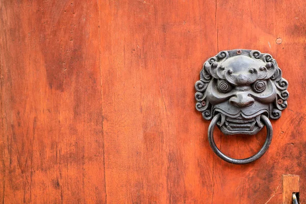 metal evil face pull door and hard wood surface background, concept : Don't open danger gate