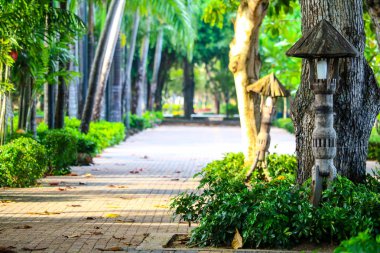 Parkta kaldırım boyunca bahçelerde süslenmiş ahşap fenerler