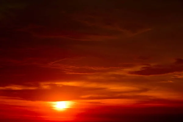 last light of sunset on the red cloud red-orange sky and ray around sun