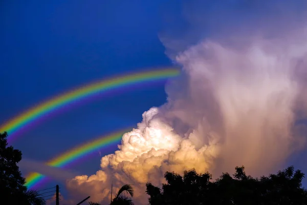 Rainbow appears in sky after the rain and back on sunset cloud — Stock Photo, Image