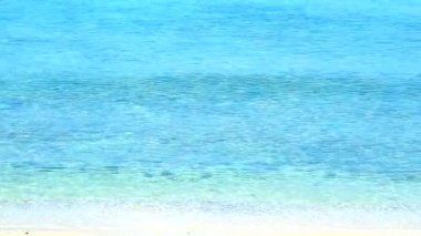 su altında kayalar ve kum görene kadar plaj ve berrak deniz suyu küçük dalga