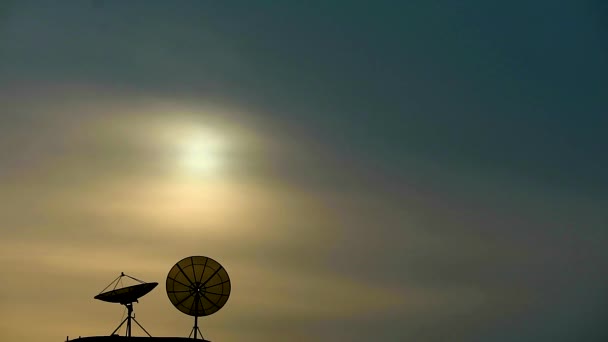 Проміжок часу захід сонця і два супутники на вершині будівлі птах літає — стокове відео