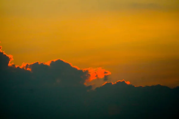 Cielo puesta del sol de nuevo en la nube de silueta oscura y naranja de rayos de sol — Foto de Stock