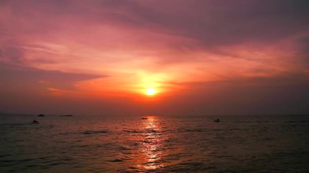 Solnedgång röd moln kvällhimmel på havet och jet ski passerar — Stockvideo