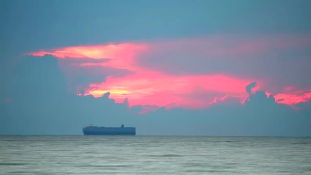 Το φορτηγό πλοίο είναι παρκαρισμένο στη θάλασσα και το σύννεφο σιλουέτας πίσω ηλιοβασίλεμα — Αρχείο Βίντεο