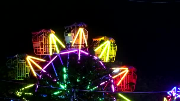 Багатокольоровий феррі колесо неону на ярмарку нічного ринку — стокове відео