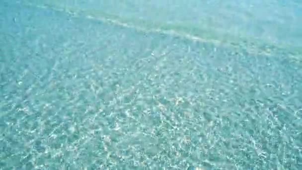Superficie de agua azul clara en el mar con reflejos de luz y oleaje — Vídeos de Stock