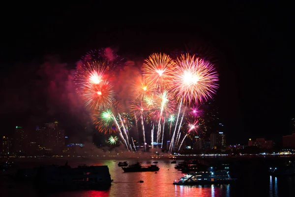 Fuochi d'artificio arcobaleno finale sulla spiaggia e colore di riflessione sull'acqua s — Foto Stock