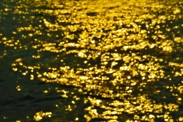 Gold color abstract of blur colorful light on sea water surface — Stock Photo, Image