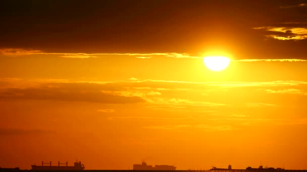 Naplementét a tengerparton narancs eget, míg a teherhajó át idő megszűnik — Stock videók