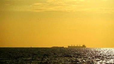 kargo gemisi ve siluet koyu turuncu sarı altın gökyüzü ne kadar aşağı günbatımı