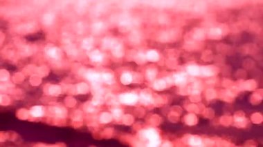 Öğleden sonra kırmızı ve beyaz bokeh yanıp sönme arka planda deniz yüzeyinde dalga bulanık yansıması