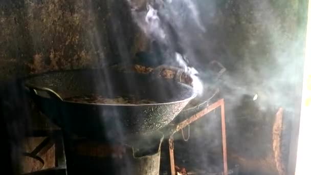 Thai food fried pork with herb leaves spicy and black pepper delicious in pan, smoke pass sunlight from hold of rust roof counrty lifestyle — Stock Video