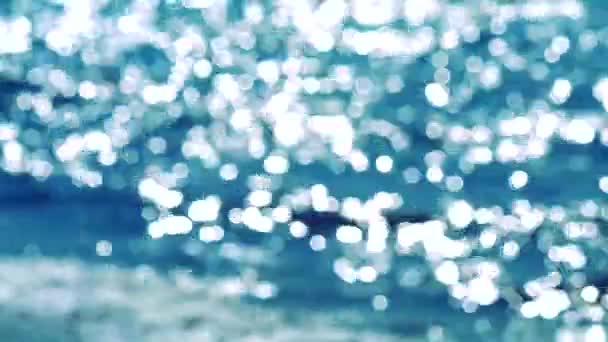 Reflejo borroso de la ola en la superficie del mar en el fondo bokeh azul y blanco verano parpadeo — Vídeo de stock