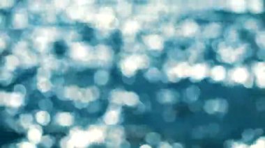 Yaz aqua mavi ve beyaz bokeh yanıp sönme arka planda deniz yüzeyinde dalga bulanık yansıması
