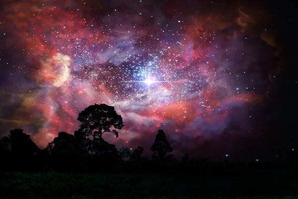 Nebulosa de poeira estelar antiga borrada de volta no céu de nuvens noturnas sobre silhou — Fotografia de Stock