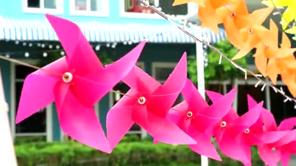 Pink windmill toy is decorated in front of shopping mall to welcome summer — Stock Video