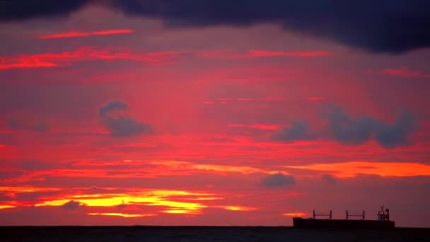 Sonnenuntergang orange gelb Himmel und dunkelrote Wolke bewegt sich auf dem Meer und Silhouette Frachtschiff und Fischerboot — Stockvideo